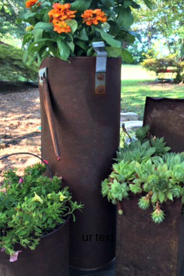 Add a little whimsy to your garden with rusty garden containers full of flowers and succulents 