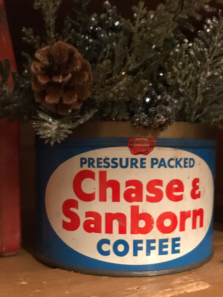 Fill vintage coffee cans with greenery to create Christmas decor